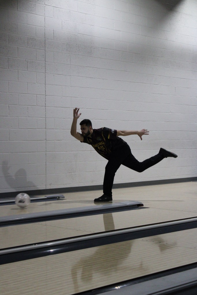 Bowling player actively bowling his ball
